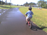 ATT00450  Biking and running around Hickam AFB - what fun racing through huge sprinklers! See how soaked Sam is already?