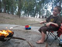 IMGP1916  Sam is roasting marshmallows with his own method - he says "You've gotta get it in the barrel, mom."