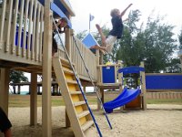 IMGP1950  Back at the playground again! This time a bunch of kids were there with us. Sam enjoyed being the sky-diving teacher, showing the kids how to jump off this 5'6" stair top. All the kids wanted to do it after watching Sam, there were five of them lined up at the top. Sam was the youngest at 5, then the next oldest was 7 (pictured here, with great flair!).