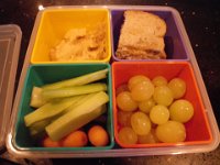 IMGP0390  Bento-style lunch...really like this concept. The Japanese eat Bento lunches in a 4:3:2:1 ratio (carb (rice usually:meat/fish:veggie (picked usually):dessert). The school is trying to avoid nut products coming in the lunches due to a severe allergy, so we have gone Pac-Rim and adopted this method to allow for more creativity. This is honey/butter on whole grain omega-3 fortified bread, hummus, veggies, grapes and Hershey's kisses (not shown).