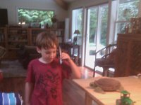 IMAG0795  Sam on the phone with Gramma telling her about digging up the geoduck. He was pacing and pacing around the table.