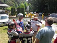 20140704 120518  Tying Growing Eagle to a hockey coach for the July 4 Parade! His asst coach, Caden, went wild over seeing an Eagle at the parade! That's Caden's dad (and head coach Brett) helping.
