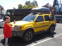 20150626 125434  I stepped into a store very briefly to look at a new purse. Found one. It was all quiet outside. It'd been 5 minutes. I wondered what was up. Here's what I found. Ben bouldering on the truck in his socks, and a lady across the lot frowning. Oy.